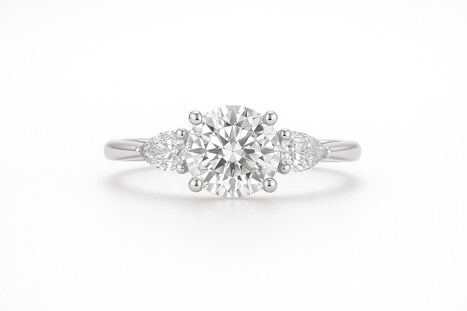 white gold engagement ring with a round center diamond and a smaller pear shaped diamond on eithe side of the center on a white background. be sure to make the center look straight ahead